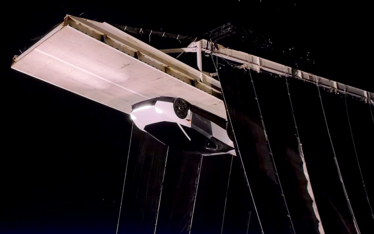 A car held upside down beneath a ceiling panel
